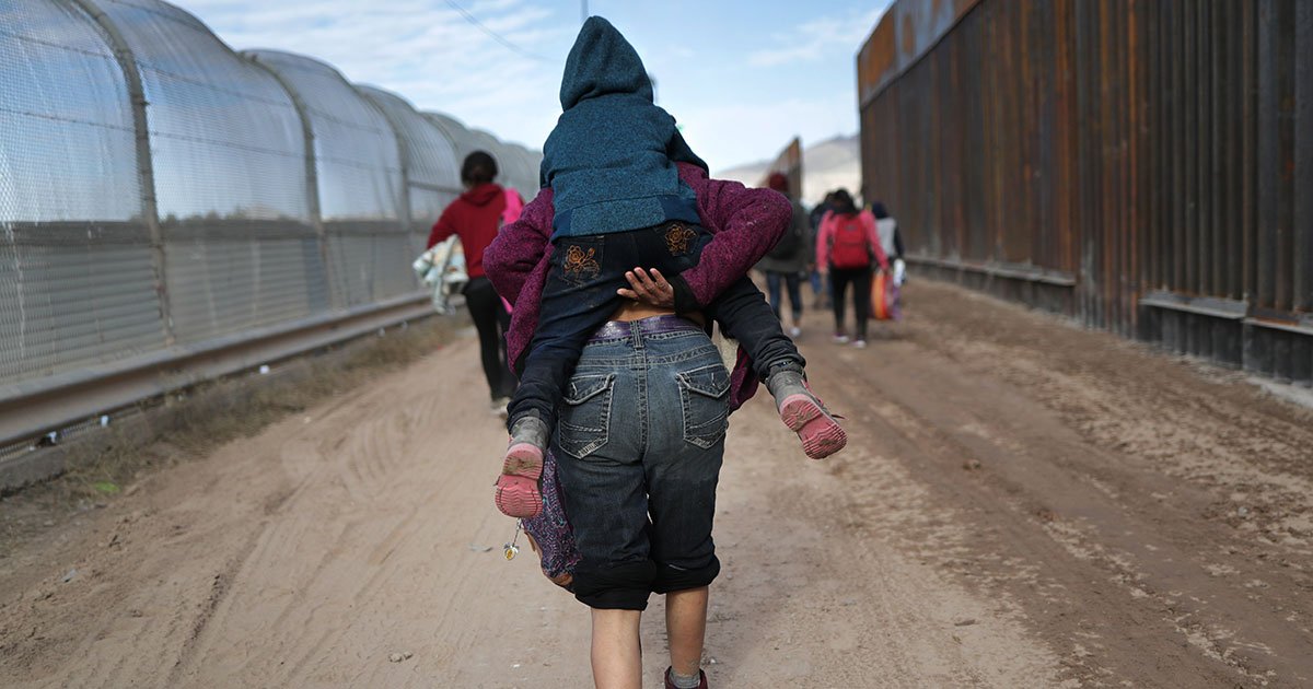 After crossing the Rio Grande into the U.S., asylum seekers walk between a newly built “bollard-style” border fence, on the right, and the older “legacy” fence. They later turned themselves in to U.S. Border Patrol agents. (Photo: John Moore/Getty Images)