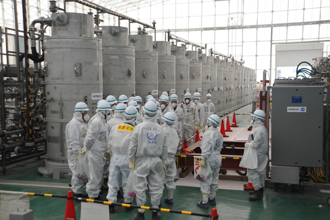 The IAEA mission team studies a water purification system that removes radioactive elements from water during a visit to the Fukushima power plant in Japan. Photo: Susanna Loof/IAEA