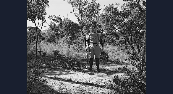DEMINER NEAR CUVELAI: The metal detector in the “deminer’s” hand casts a sinister circular shadow on the ground at his feet, hinting at the landmines that may be concealed all around him.