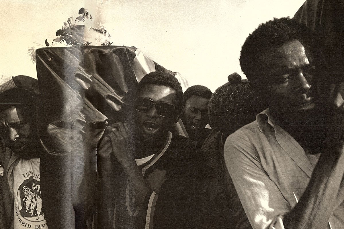 A 1984 photograph by Omar Badsha of a funeral in KwaMashu of two ANC soldiers killed in clashes with the police outside Stanger. The photo is part of South Africa: The Cordoned Heart, a seminal photographic exhibition and book project of the Second Carnegie Inquiry into Poverty and Development in Southern Africa.